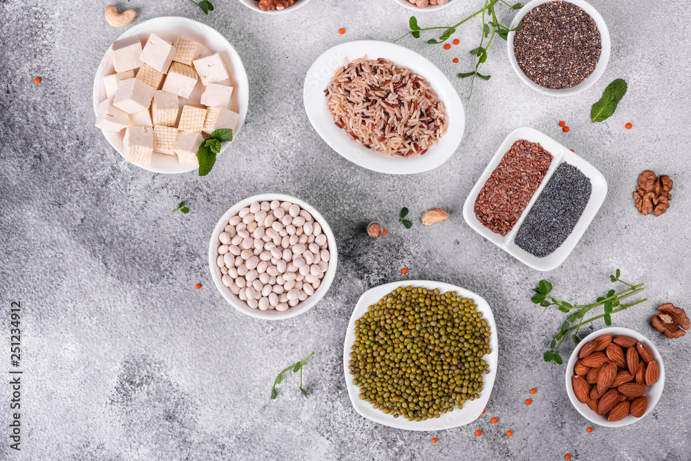 Superfoods on a gray background with copy space. Nuts, beans, greens and seeds. Healthy vegan food Superfoods on a gray background with copy space. Nuts, beans, greens and seeds. Healthy vegan food