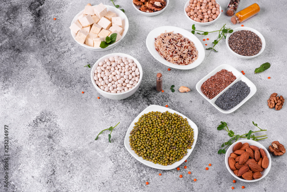 Superfoods on a gray background with copy space. Nuts, beans, greens and seeds. Healthy vegan food Superfoods on a gray background with copy space. Nuts, beans, greens and seeds. Healthy vegan food