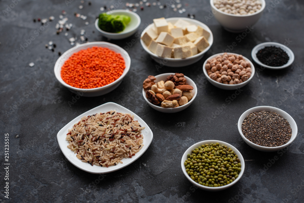 Superfoods on a gray background with copy space. Nuts, beans, greens and seeds. Healthy vegan food Superfoods on a gray background with copy space. Nuts, beans, greens and seeds. Healthy vegan food