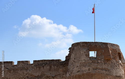 Flagge auf dem Eckturm des Bahrain-Forts vor strahlend blauem Himmel photo