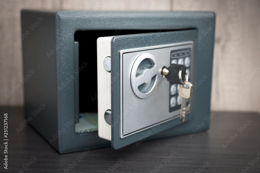 open safe with keys on the door on a light background - obrazy, fototapety, plakaty 