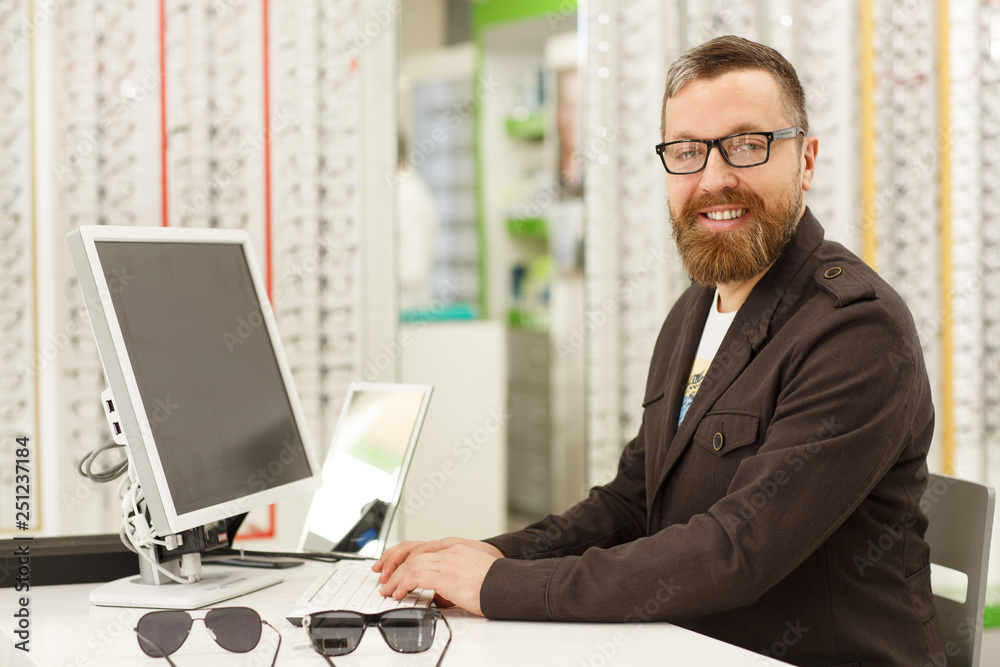 custom made wallpaper toronto digitalHorizontal portrait of a cheerful mature male professional optometrist working at his eyewear store. Handsome male optician smiling to the camera, using his computer