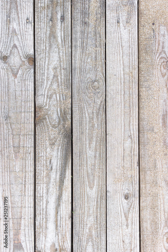 Wooden background. Boards in the sand. Wooden walkway on the sandy beach. Natural materials. The texture of the wooden surface. Beach landscape.