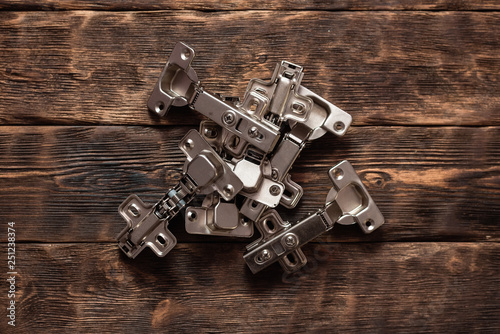 Door hinges on a wooden table background. Top view. photo