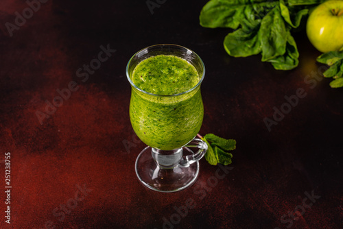 Ginger green apple smoothie on concrete background. It can be used as a background
