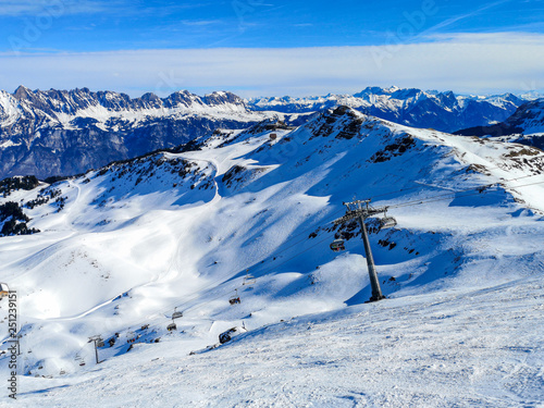 Skilift im Skigebiet Flumserberg, Schweiz. Schneebedeckte Berge und blauer Himmel.  photo