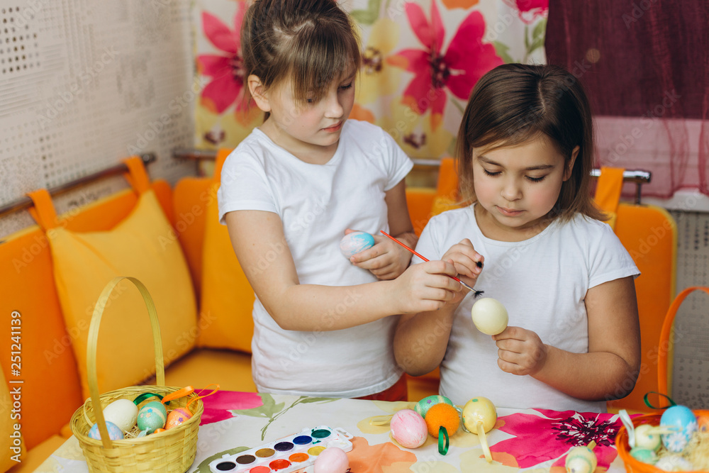 Two cute pretty preschool girl prepare easter eggs, drawing eggs together. Friendship, childhood, easter concept Two cute pretty preschool girl prepare easter eggs, drawing eggs together. Friendship, childhood, easter concept