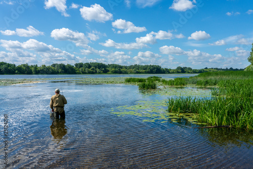 Fisherman with a fishing rod on the background of nature © Игорь Кляхин