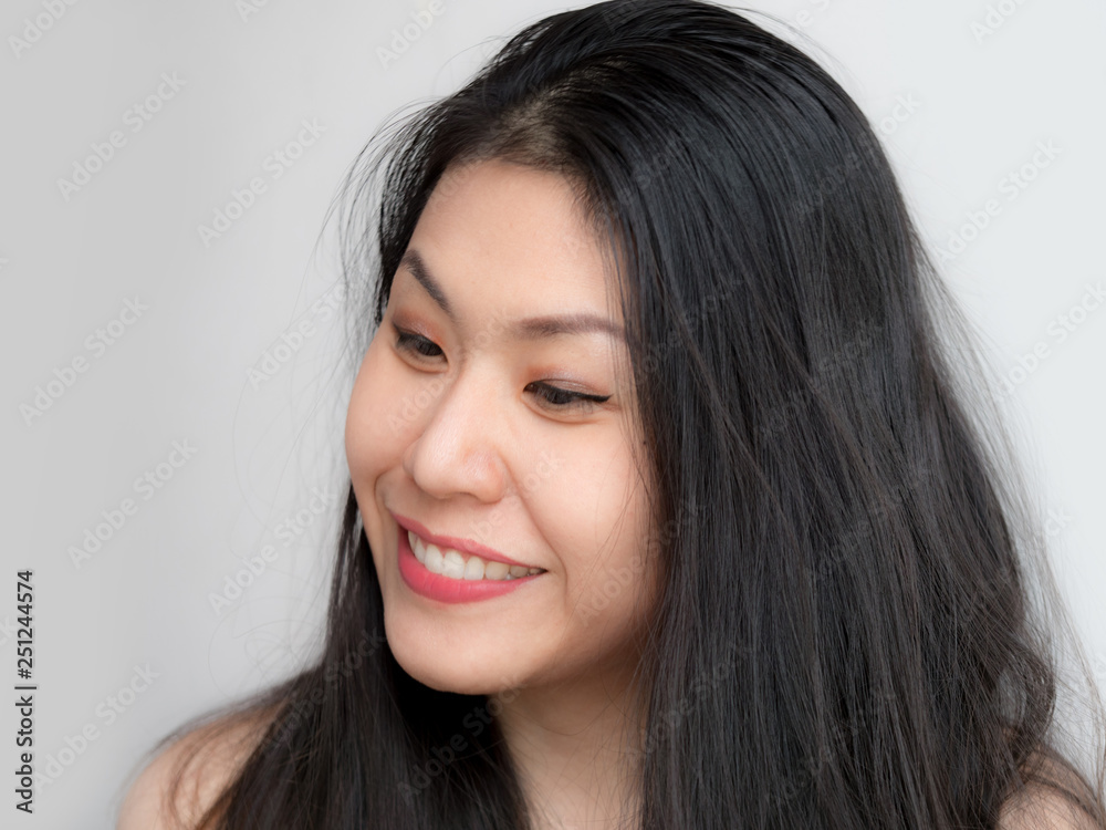 Headshot of Relaxed confident happy Asian Thai Chinese woman smiling with black hair, makeup, happy fresh on white background looking to the side towards Headshot of Relaxed confident happy Asian Thai Chinese woman smiling with black hair, makeup, happy fresh on white background looking to the side towards
