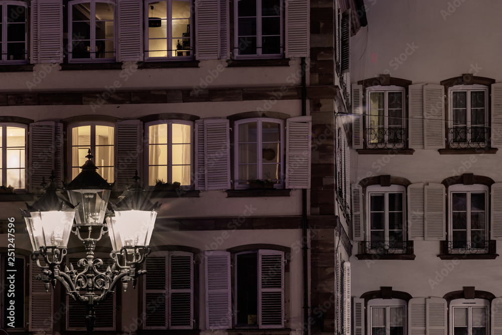 Street lamp and buildings with highlighted windows, night view of Strasbourg
