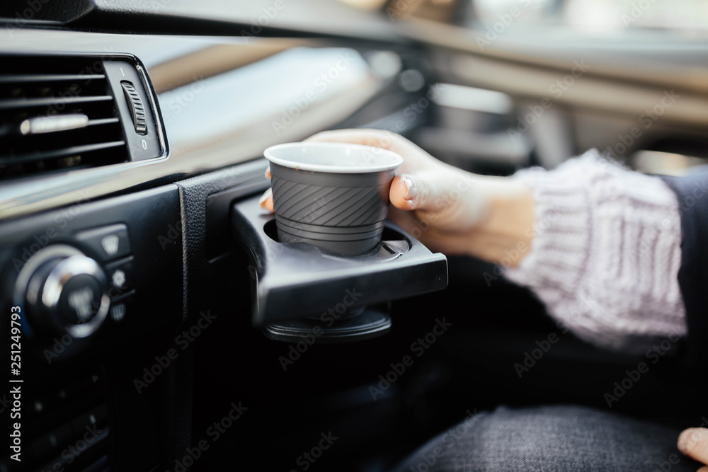 cup holder in the car. female hand with coffee on a trip. Stock