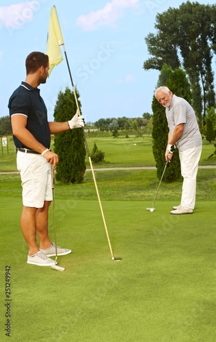 Young and old man golfing together