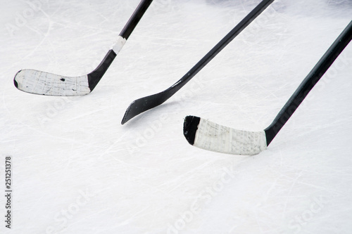 Foto Three black ice hockey sticks on the court