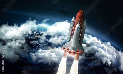 Fototapeta Naklejka Na Ścianę i Meble -  Space shuttle in the space near Earth. Clouds and sky on background. Atmosphere. Elements of this image furnished by NASA