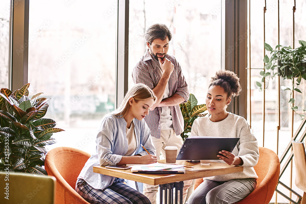 Don’t try to be original, just try to be good. Concept of presentation new business project. Portrait of three colleagues working together in creative office
