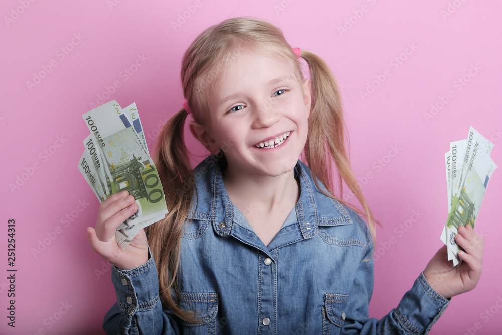 business and money concept - happy little girl with euro cash money over pink background business and money concept - happy little girl with euro cash money over pink background