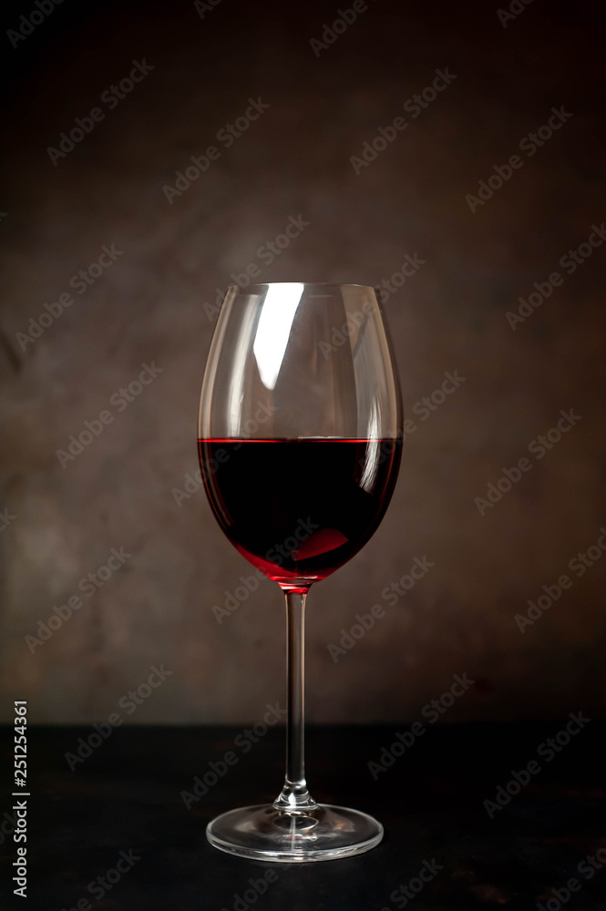 wine glass with red wine on a stone background