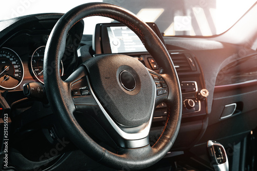 Dark luxury car Interior - steering wheel, shift lever and dashboard. © Akaberka
