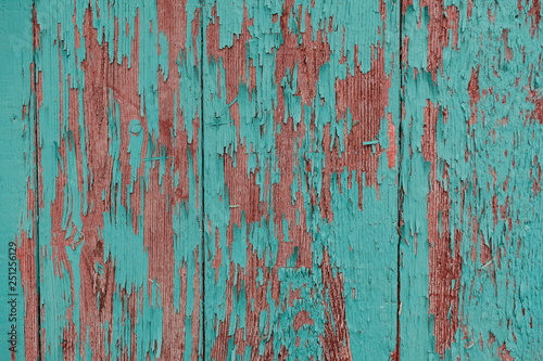 cracked vertical wooden panel with peeling green paint, textured surface background