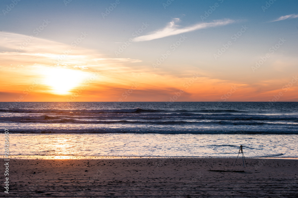 Camera with tripod shooting sunset at the beach with beautiful sunset. Camera with tripod shooting sunset at the beach with beautiful sunset.