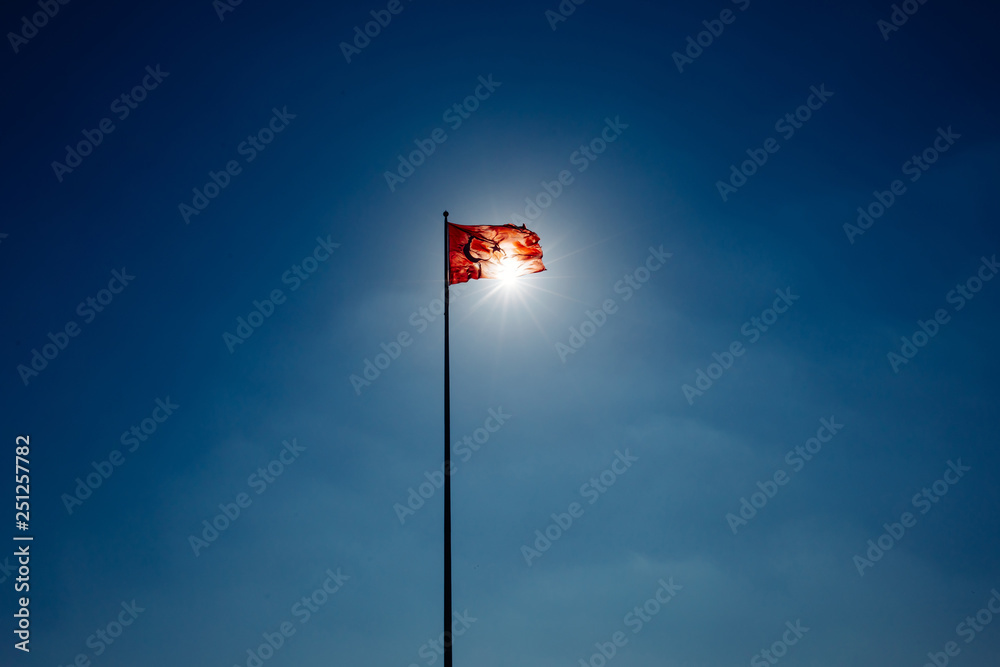 Turkish flag waving at sky with sun. Turkey country flag flowing in the wind in front of sun. Rising Turkey or Rise of Turkey.