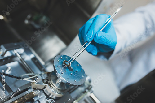 Researcher, scientist, physicist or laboratory assistant working, experimenting and analyzing in modern lab with equipments, tools and machines. photo