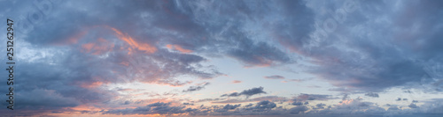 Twilight sunset. Panorama of cloudy sky with colorful clouds from blue to orange. High resolution panoramic sky. Cumulus formation