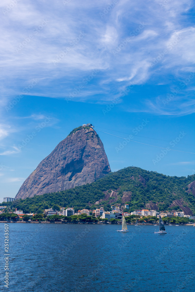 Beautiful panoramic view of the Sugar Loaf mountain in Rio de Janeiro, Brazil, on a beautiful and relaxing sunny day with blue sky and white clouds Beautiful panoramic view of the Sugar Loaf mountain in Rio de Janeiro, Brazil, on a beautiful and relaxing sunny day with blue sky and white clouds