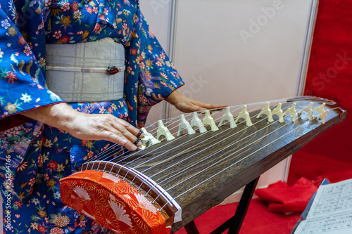 Woman in kimono dress Japanese traditional instrument koto plays photo