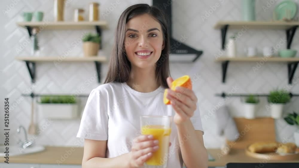 Smiling woman making orange juice in the morning Smiling woman making orange juice in the morning