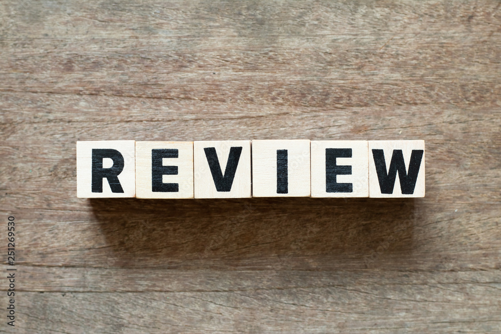 Obraz premium Letter block in word review on wood background