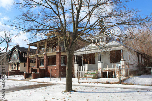 Two abandoned homes, an American Foursquare and a Michigan Bungalow, in Detroit's Martin Park neighborhood in winter