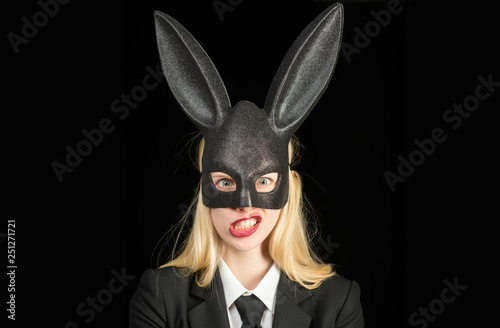 Sexy woman with mask Easter bunny on a black background and looks very sensually. Closeup of winking bunny girl face. Sexy woman wearing a mask Easter bunny and looks very sensually.