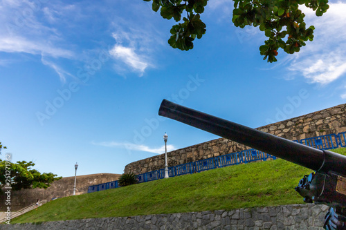 old cannon with blue sky and white clouds in the background photo