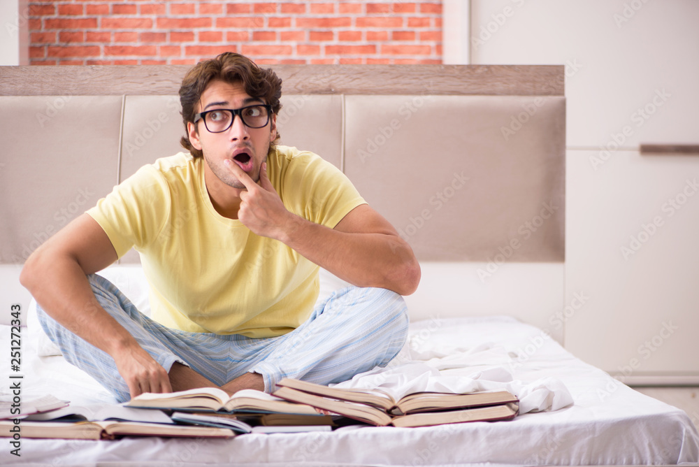 Young student studying in bed for exams Young student studying in bed for exams
