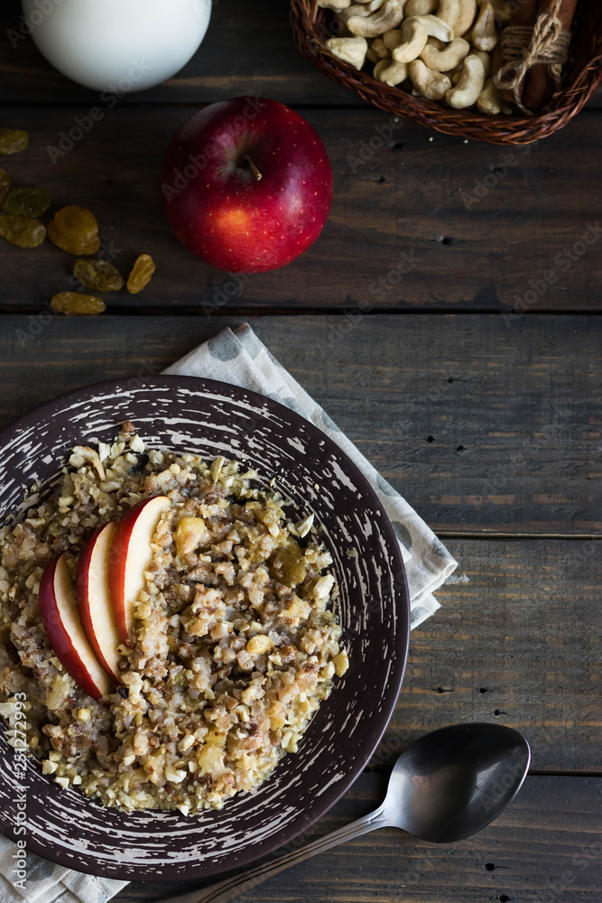 Fototapeta premium Buckwheat porridge with milk, apple, raisins and cashew nuts