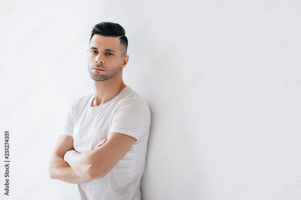 Confident handsome man with crossed arms with copy space Confident handsome man with crossed arms with copy space