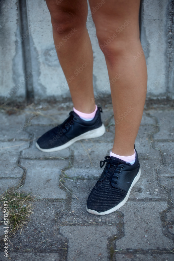 close-up of woman legs, wearing sneakers, outdoors. close-up of woman legs, wearing sneakers, outdoors.