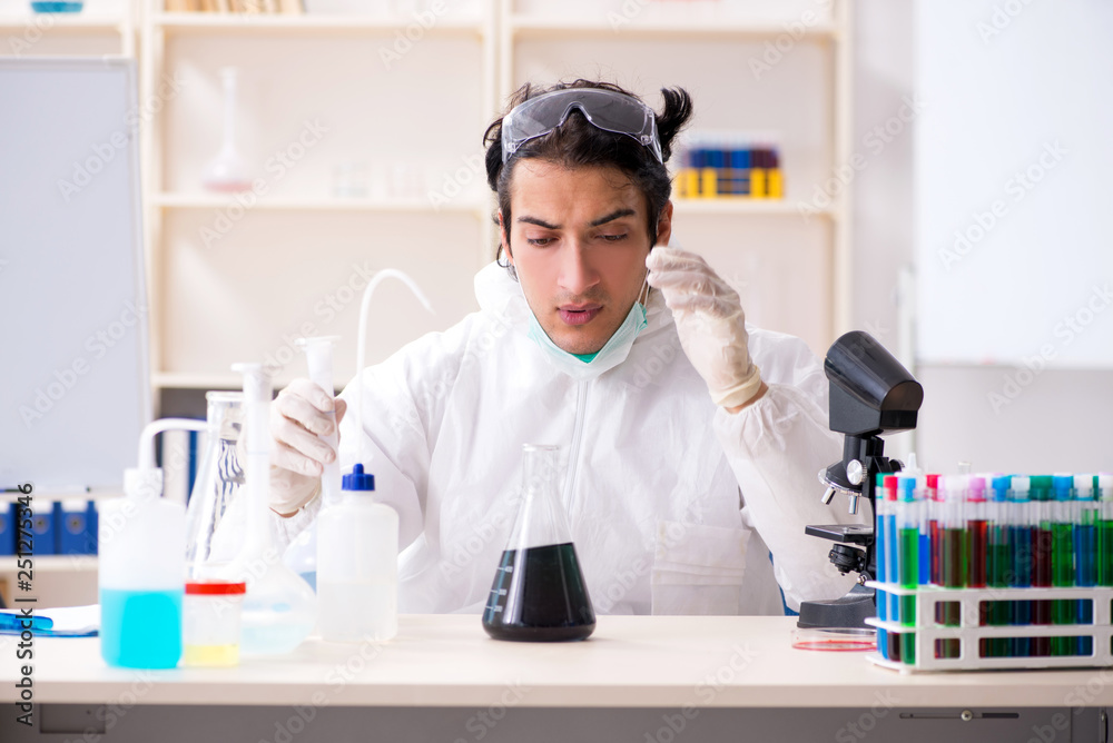Young handsome chemist working in the lab Young handsome chemist working in the lab