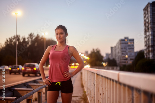 one young woman, looking to camera, posing on bridge, wearing sport clothes. © HD92