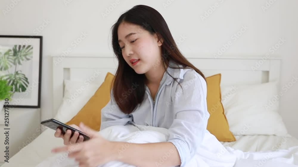 Young woman shocking and using with her phone at bedroom. Young woman shocking and using with her phone at bedroom.