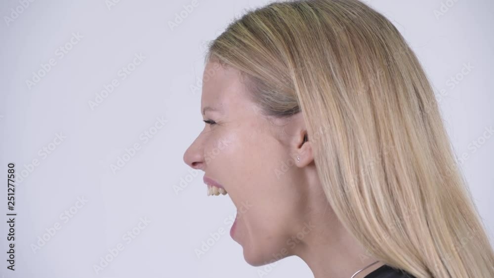 Closeup profile view of young angry blonde woman shouting Closeup profile view of young angry blonde woman shouting