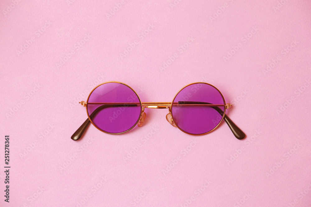 single transparent round pink glasses on uniform coral background, temple arm of eyeglasses are closed, front view single transparent round pink glasses on uniform coral background, temple arm of eyeglasses are closed, front view
