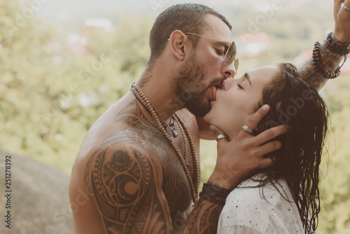 Handsome muscular guy and amazing sexy woman. Cosmopolitan couple. Love and flirt. Muscular man and fit slim young female kissing. Couple goals. photo