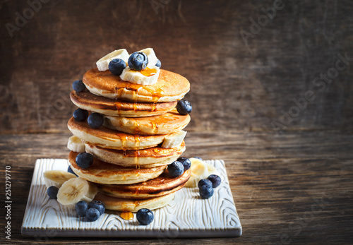 Pancakes with banana, blueberry and maple syrup for a breakfast