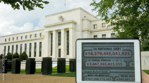 a debt clock and the exterior of the federal reserve building photo