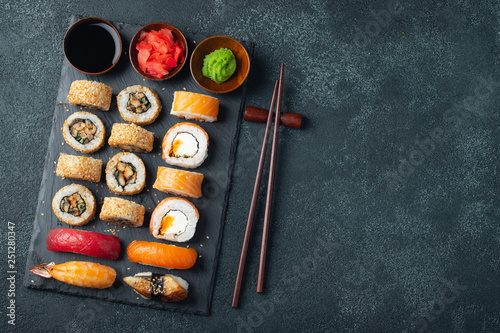Set of sushi and maki on stone table.