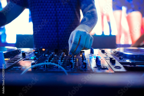 Dj mixing outdoor at beach party festival with crowd of people in background - Summer nightlife view of disco club outside