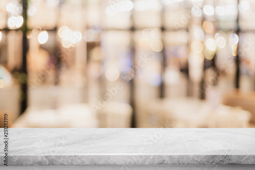 Empty white marble stone table top on blurred with bokeh cafe and restaurent interior background - can be used for display or montage your products
