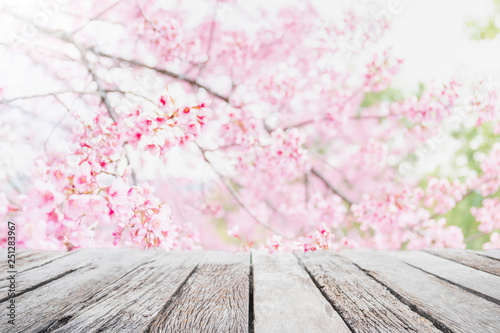 Empty wood table top and blurred sakura flower tree in garden background with vintage filter - can used for display or montage your products.